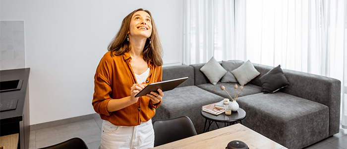 Automação residencial: Mulher acendendo luz em casa automatizada.